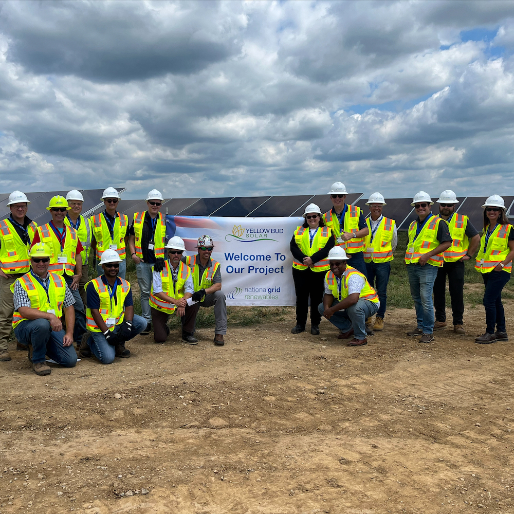 Group of people in front of solar panels at Yellowbud Solar project