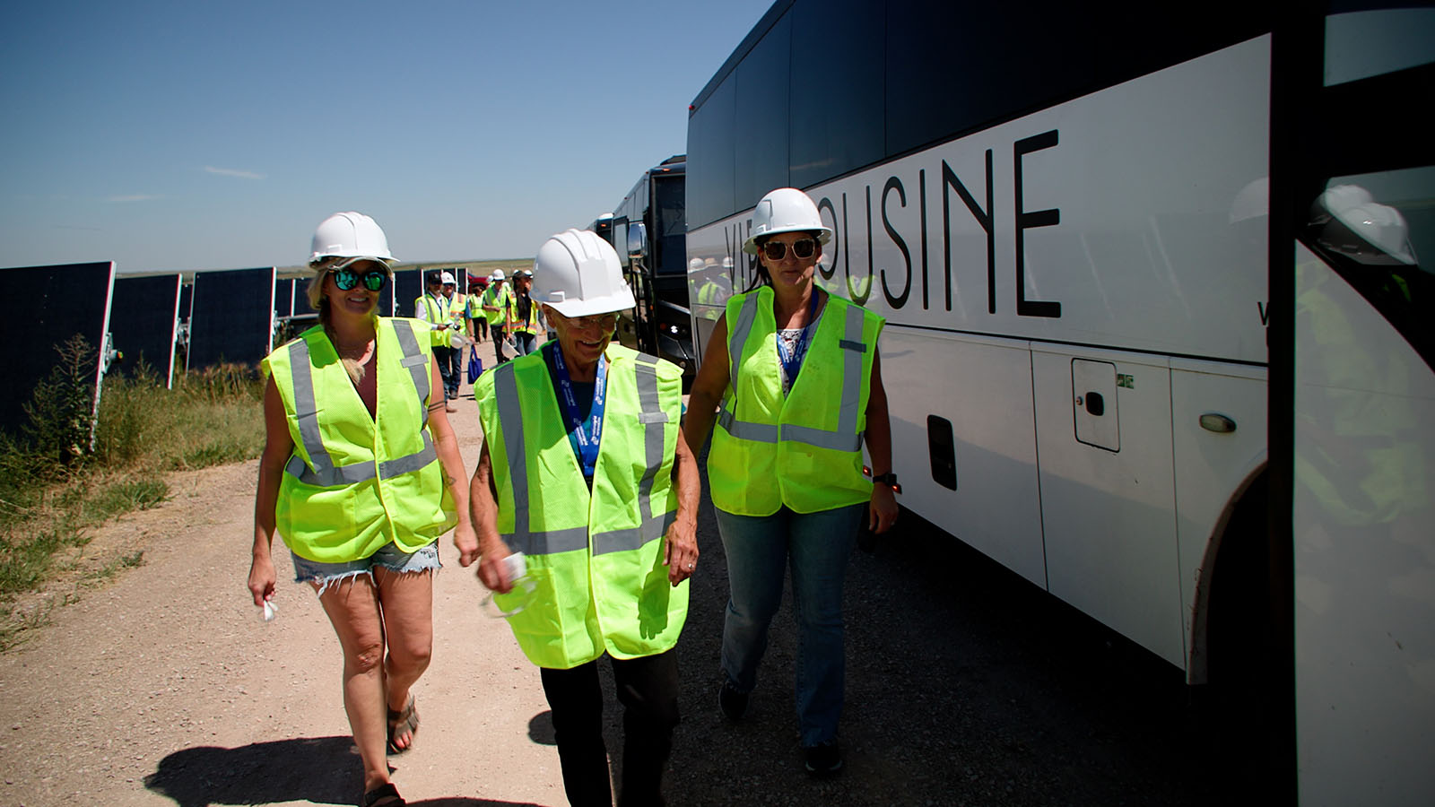 People at Wild Springs solar event next to buses
