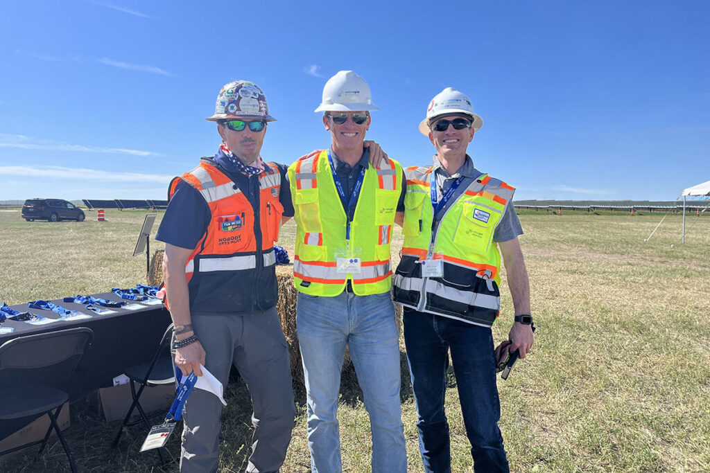 People with hard hats and construction vests at solar farm