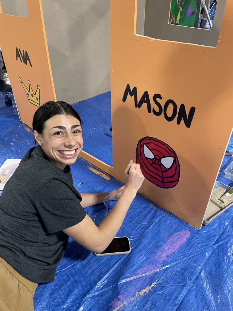 Team member painting a playhouse
