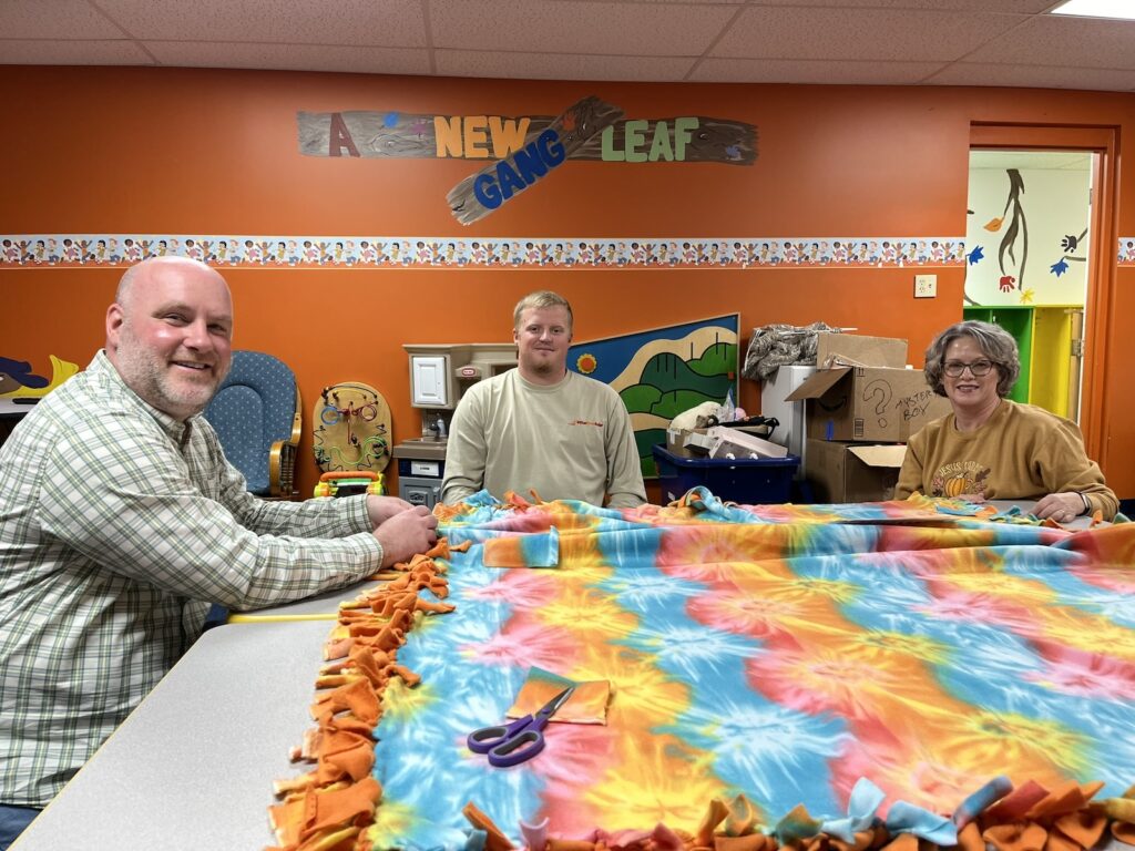 People making a tie blanket
