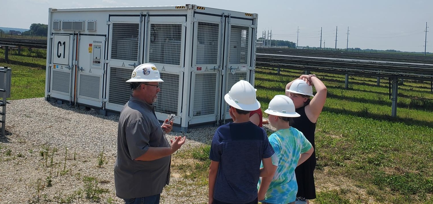 People with hard hats at solar farm