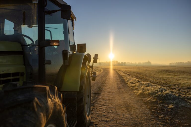Tractor parked on an agricultural path during sunset